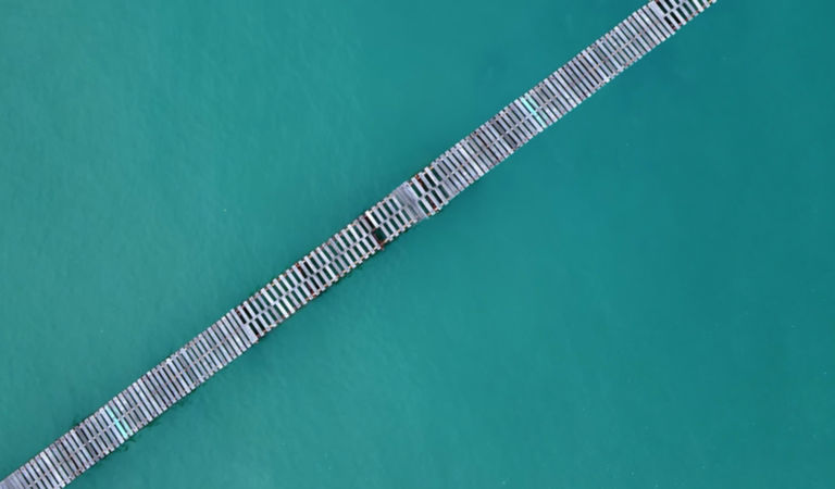 Aerial view of wooden footbridge across ocean