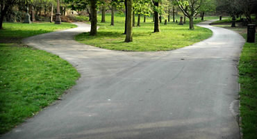 Forked road in St. James Gardens, Liverpool. St James's Cemetery is an urban park behind the Liverpool Cathedral. This photo symbolise a choice between two different paths. Diminishing perspective point of view..