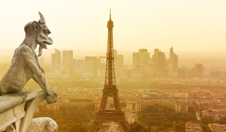 Gargoyle figur on Notre Dame looking towards Eiffel Tower