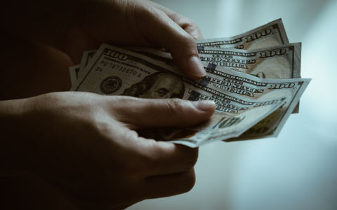 hands holding counting american dollar