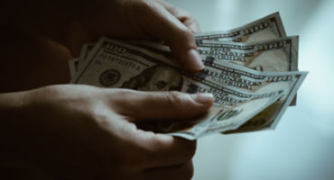 hands holding counting american dollar