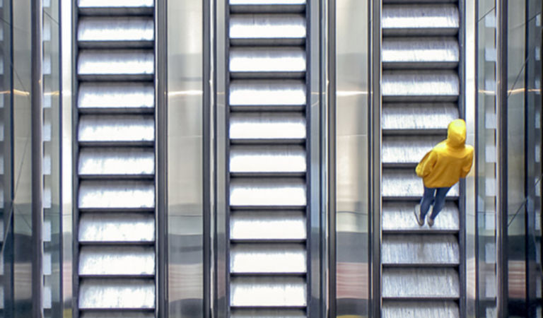 man is going up the escalator