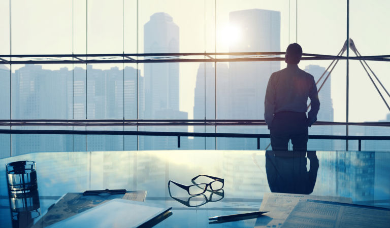 man-standing-beside-clear-glass-window-hero-761527348-1280x823